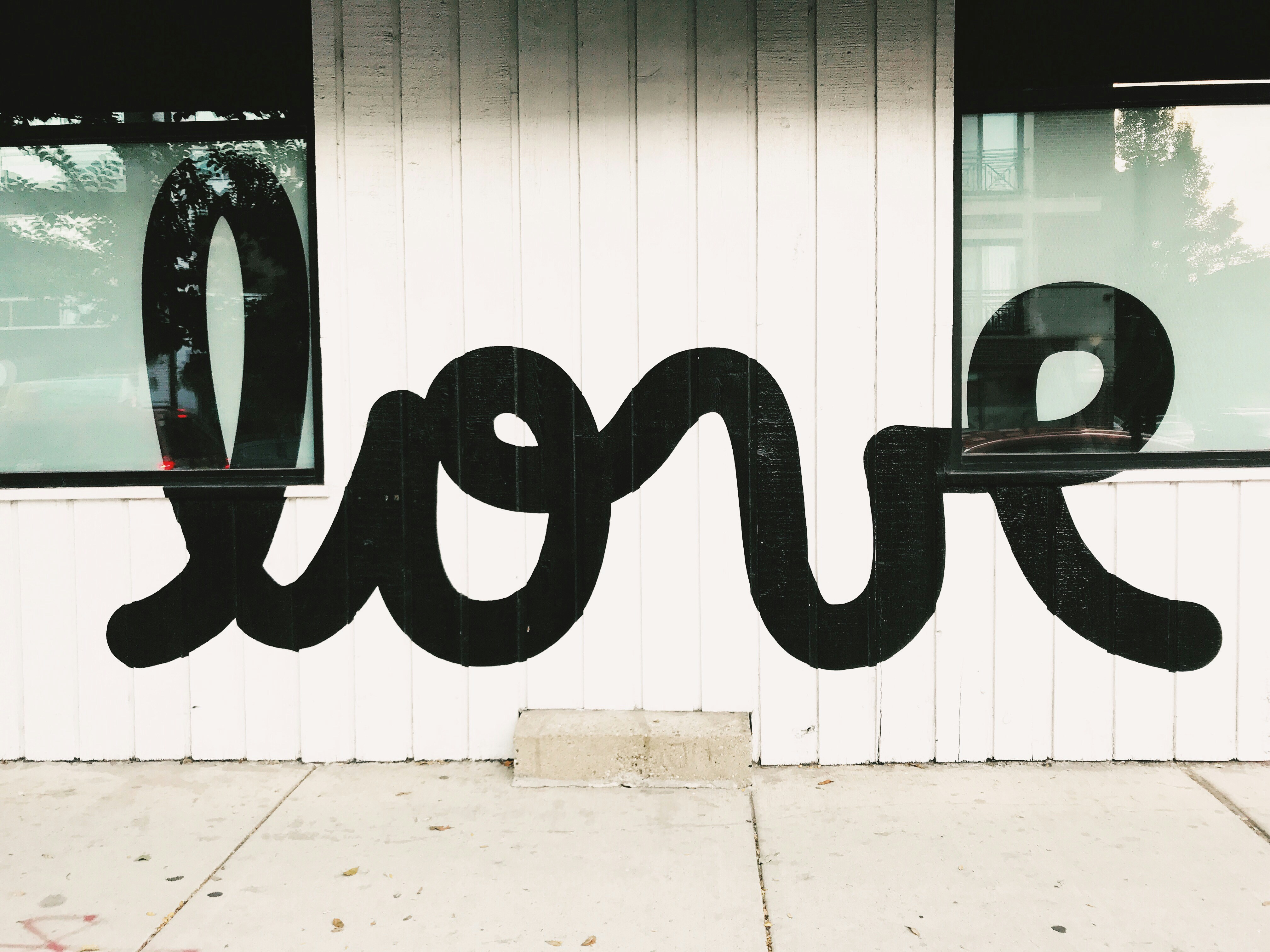 Street art of the word Love in flowing black script — the simplest, most powerful word